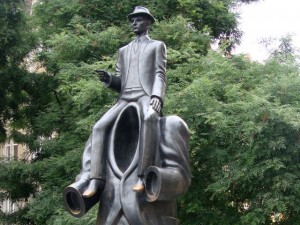statue of man sitting on the shoulders of a giant